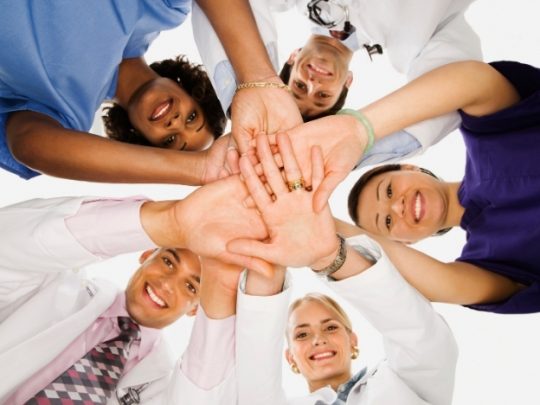 Group of healthcare workers together with hands